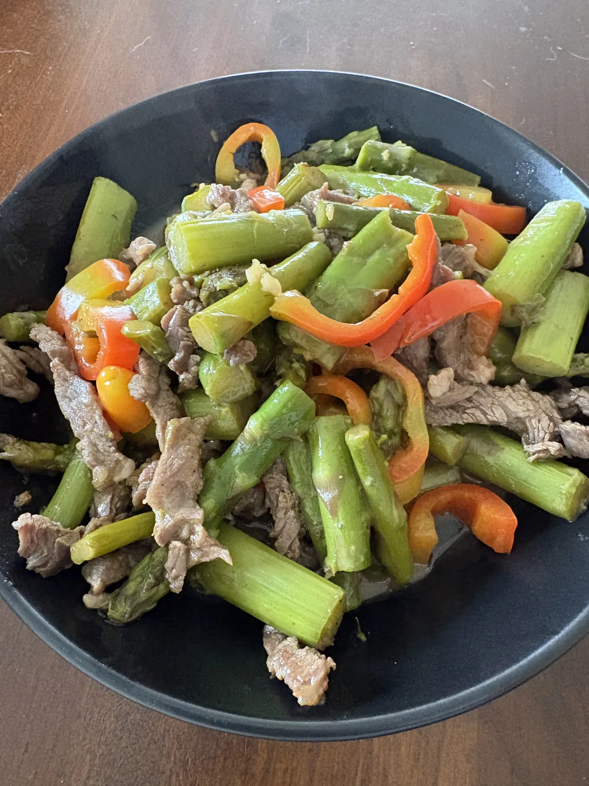 Rindfleisch-Spargel-Pfanne im Wok mit glänzender Soße, zarte Rindfleischstreifen und leuchtend grüner Spargel